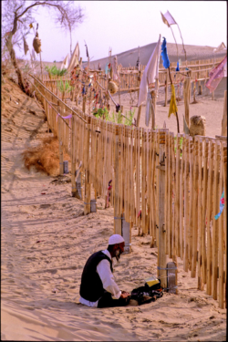 Ce pèlerin se receuille sur le tombeau de l'Imam Asim à côté de Khotan, au milieu des sables du Taklamakan.
